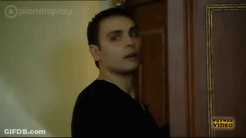 Man In Black Shirt In Front Of Payne Video Door GIF