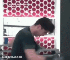 Man In Black Shirt In Front Of Red Circle Wall GIF