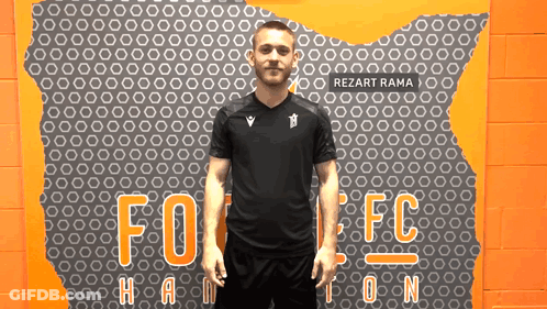 Man In Black Shirt In Front Of Rezart Rama Wall GIF