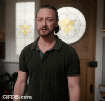 Man In Black Shirt In Front Of Stained Glass Door GIF