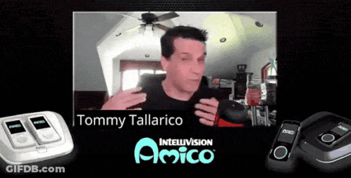 Man In Black Shirt In Front Of Tommy Tallarico Sign GIF