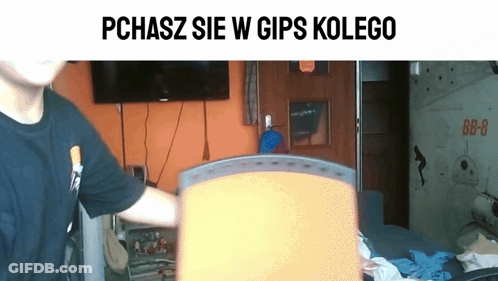 Man In Black Shirt In Front Of TV Saying Pchasz Sie W Gips Kolego GIF