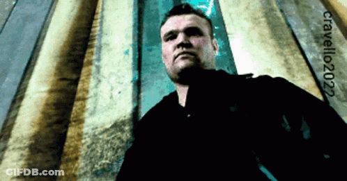 Man In Black Shirt In Front Of Wall With 2022 GIF