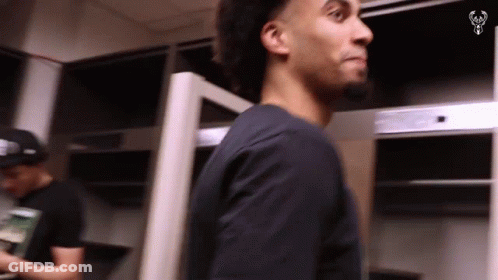 Man In Black Shirt In Locker Room Looking At Something GIF
