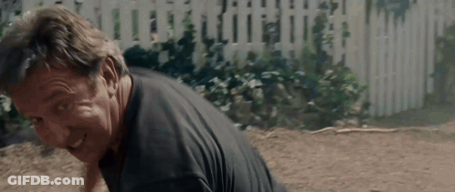 Man In Black Shirt Laying On Ground With White Picket Fence GIF