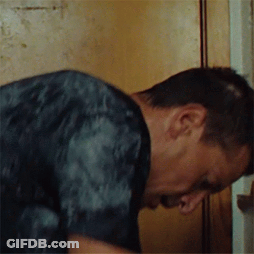 Man In Black Shirt Leaning Against Wall GIF