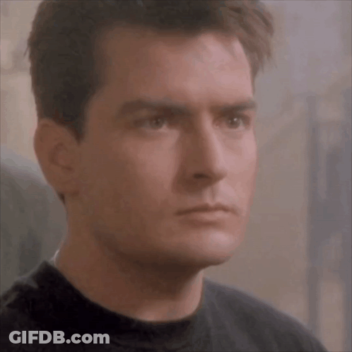 Man In Black Shirt Looking At Camera GIF