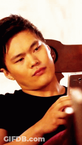 Man In Black Shirt Looking At Phone GIF
