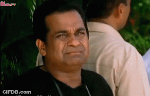 Man In Black Shirt Making Funny Face In Front Of Group GIF