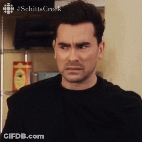 Man In Black Shirt Making Funny Face Looking At Camera GIF