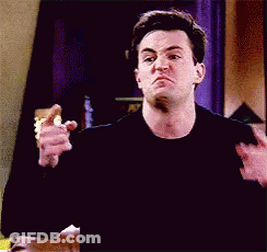 Man In Black Shirt Making Funny Face While Holding Pink Shoes GIF
