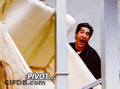 Man In Black Shirt Peeking Behind Couch Saying Pivot GIF