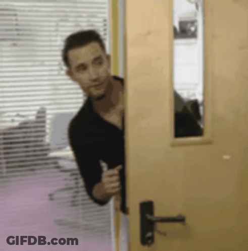 Man In Black Shirt Peeking Out Of Door GIF