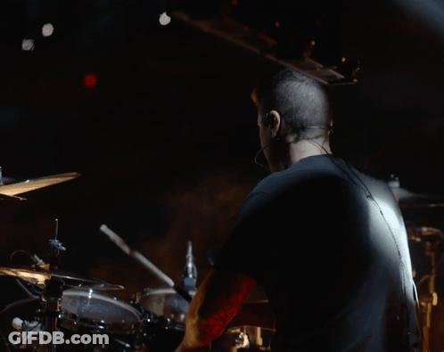 Man In Black Shirt Playing Drums In Dark Room GIF
