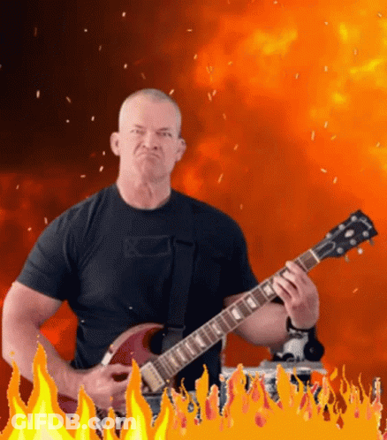 Man In Black Shirt Playing Gibson Guitar In Front Of Flames GIF