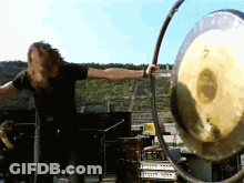 Man In Black Shirt Playing Gong GIF
