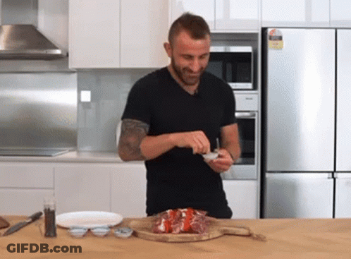 Man In Black Shirt Preparing Food In Kitchen With Miele Refrigerator GIF