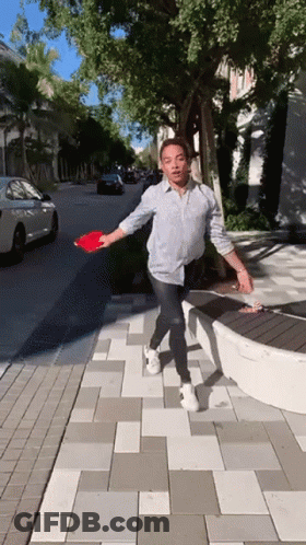 Man In Black Shirt Reaching Toward Lamp With Clueless GIF
