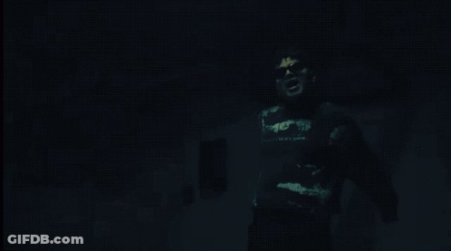 Man In Black Shirt Saying A In Dark Room GIF