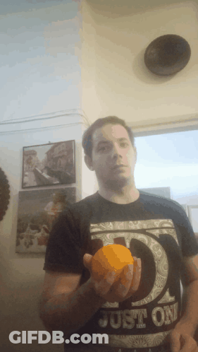 Man In Black Shirt Saying Just Holding Orange GIF