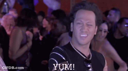 Man In Black Shirt Says Yum In Crowd GIF