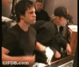 Man In Black Shirt Sitting At Desk With Keyboard GIF