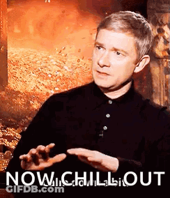 Man In Black Shirt Sitting By Fire Saying Now Chill Out GIF