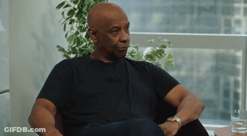 Man In Black Shirt Sitting By Window With Plant GIF
