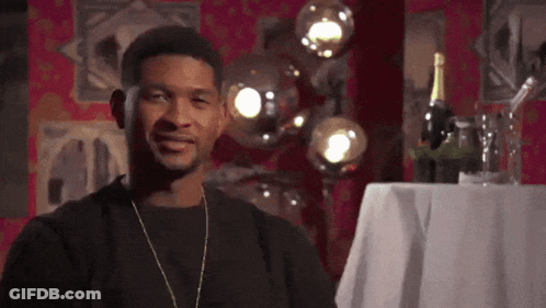 Man In Black Shirt Smiling Next To Wine Bottle GIF