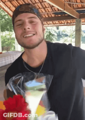 Man In Black Shirt Smiling While Holding Bag Of Food GIF