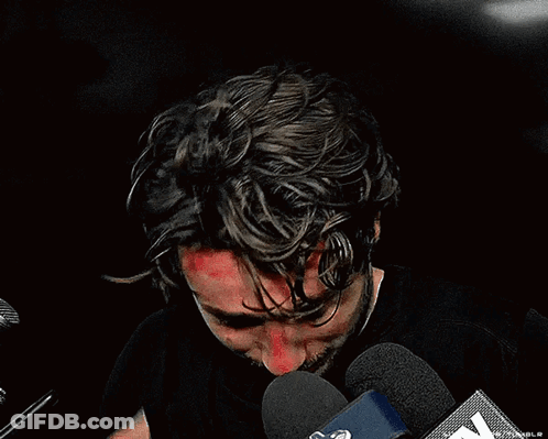 Man In Black Shirt Speaking Into Microphone GIF
