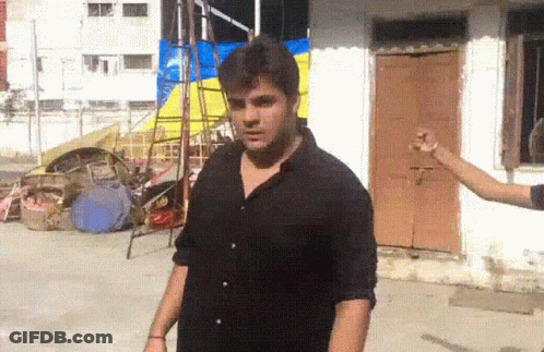 Man In Black Shirt Standing In Front Of Brown Door GIF