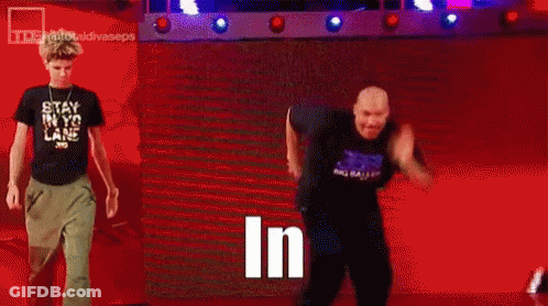 Man In Black Shirt Standing In Front Of Crowd Saying In GIF