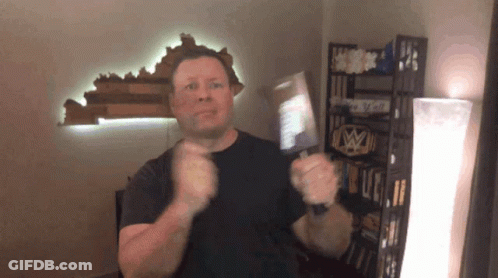 Man In Black Shirt Standing In Front Of Shelf Saying I Love You GIF