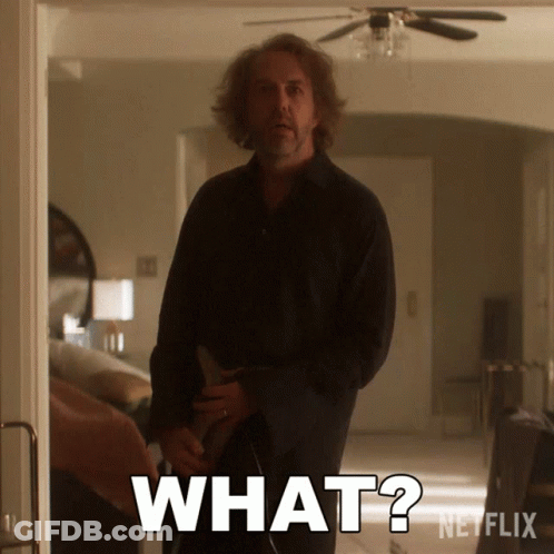Man In Black Shirt Standing In Room With Words What GIF