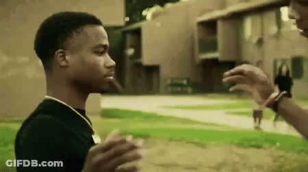 Man In Black Shirt Standing Next To Another Man In Field GIF