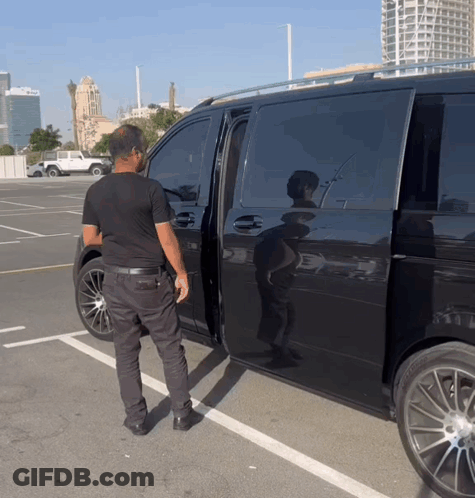 Man In Black Shirt Standing Next To Black Van GIF