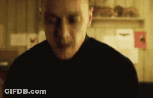 Man In Black Shirt Standing With Eyes Closed In Dark Room GIF