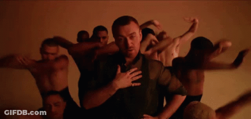 Man In Black Shirt Surrounded By Naked Men Dancing GIF