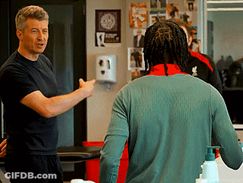 Man In Black Shirt Talking To Man In Green Sweater GIF