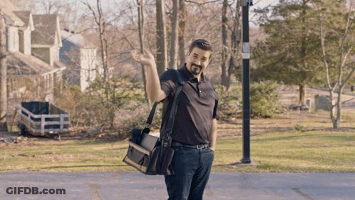 Man In Black Shirt Waving With Tool Bag GIF