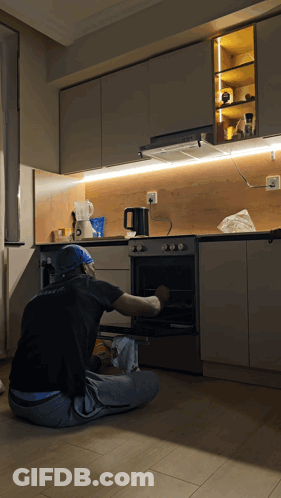 Man In Black Shirt With A Kneeling At Oven GIF