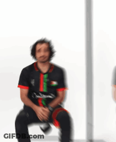 Man In Black Shirt With Arabic Writing Sitting In Chair GIF