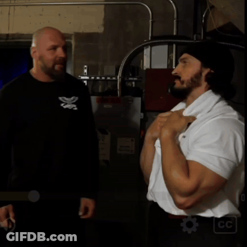 Man In Black Shirt With Butterfly Talking To Man In White Shirt GIF