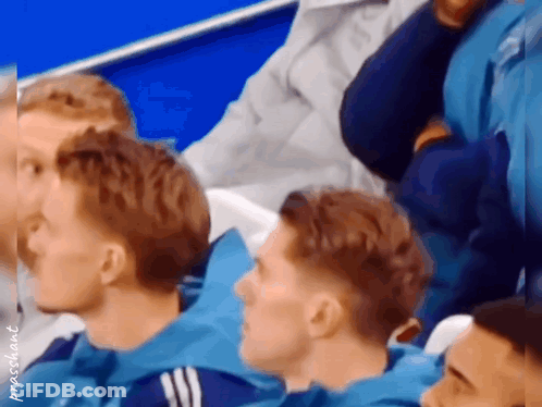 Man In Black Shirt With Crown Dancing In Front Of Manchester Logo GIF
