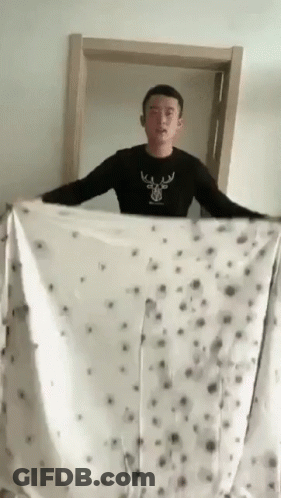 Man In Black Shirt With Deer Holding Blanket GIF