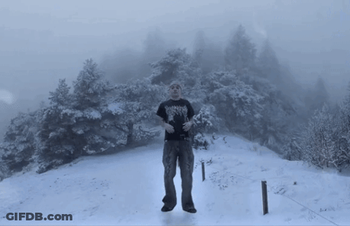 Man In Black Shirt With Heavy Metal In Snow GIF