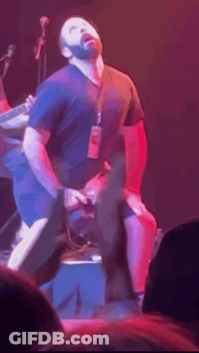 Man In Black Shirt With Lanyard On Stage GIF