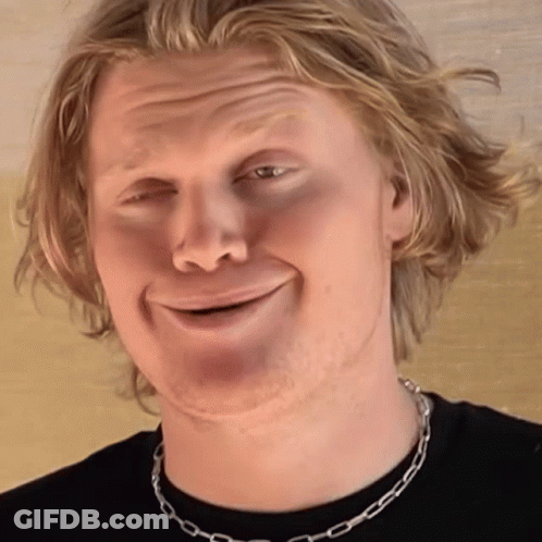 Man In Black Shirt With Silver Chain Smiling GIF