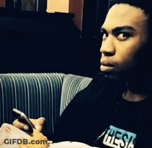 Man In Black Shirt With Thesis Looking At Phone GIF
